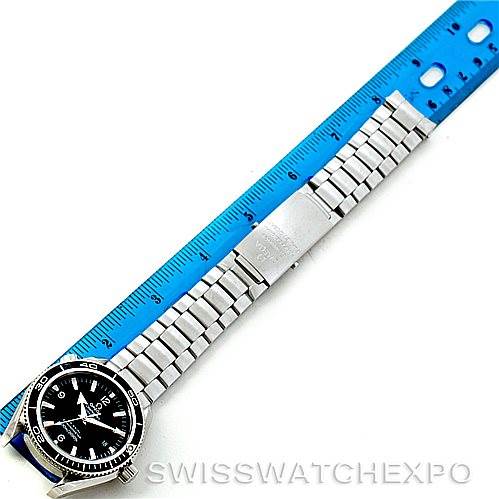 The image shows the Omega Planet Ocean 2201.50.00 Men
s Stainless Steel Black Dial 2201.50.00 Men
s Stainless Steel Black Dial watch laid flat next to a ruler, displaying its bezel, dial, and entire metal bracelet from an overhead angle.