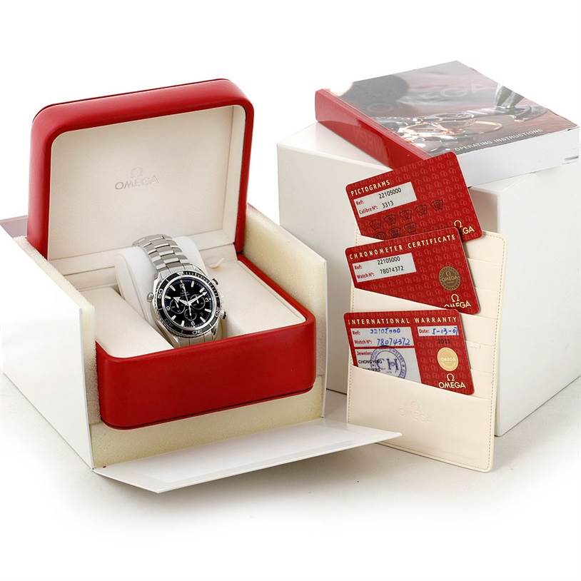 This image shows the Omega Planet Ocean 2210.50.00 Men
s Stainless Steel Black Dial 2210.50.00 Men
s Stainless Steel Black Dial watch in its box along with its warranty, chronometer certificate, and pictograms card.