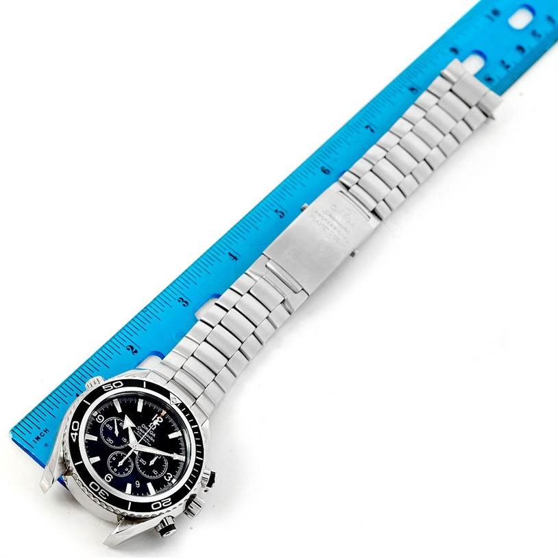 The Omega Planet Ocean 2210.50.00 Men
s Stainless Steel Black Dial 2210.50.00 Men
s Stainless Steel Black Dial watch is shown from an angled top view, highlighting its face, bezel, and stainless steel bracelet alongside a ruler.