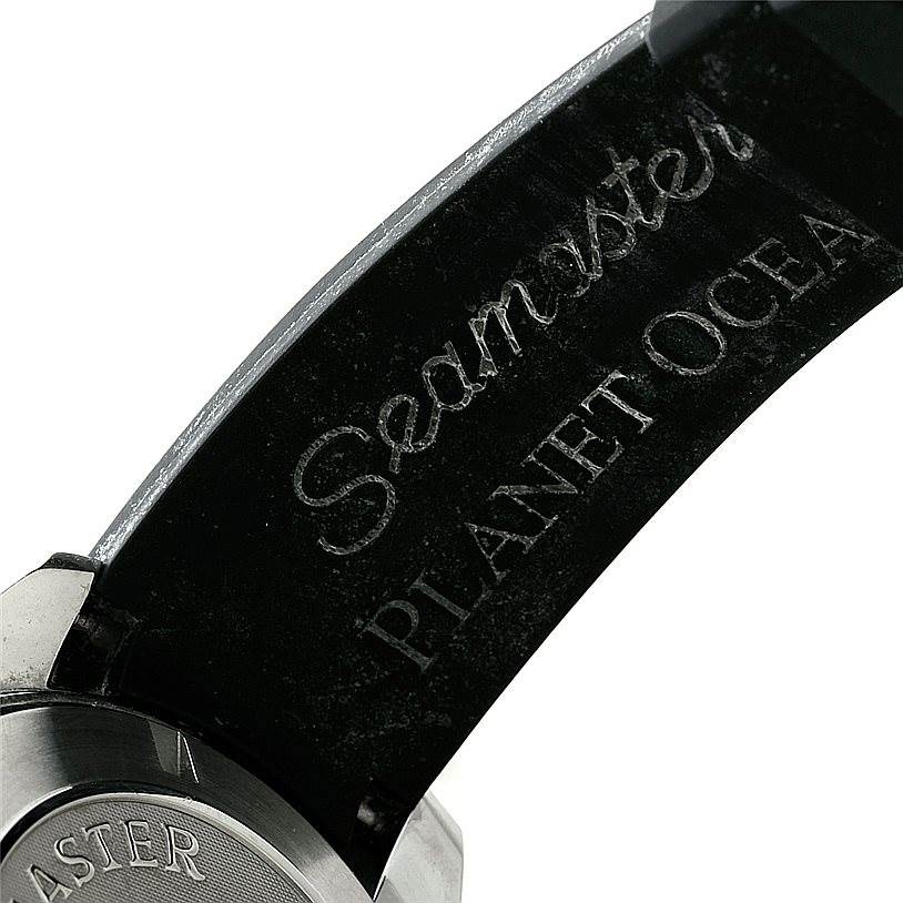 The image shows the back of the Omega Planet Ocean 2909.50.91 Men
s Stainless Steel Black Dial 2909.50.91 Men
s Stainless Steel Black Dial watch and the interior side of its strap engraved with "Seamaster Planet Ocean."