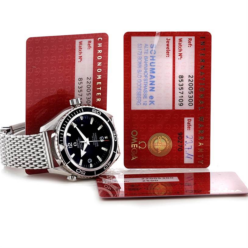 This image shows an Omega Planet Ocean 2200.50.00 Men's Stainless Steel Black Dial 2200.50.00 Men's Stainless Steel Black Dial watch with its face, bezel, and metal bracelet, alongside warranty cards.