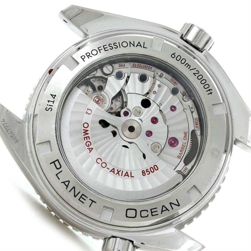 The image shows the case back and movement of the Omega Planet Ocean 232.30.46.21.01.003 Men
s Stainless Steel Black Dial 232.30.46.21.01.003 Men
s Stainless Steel Black Dial watch, highlighting the Co-Axial 8500 caliber mechanism.