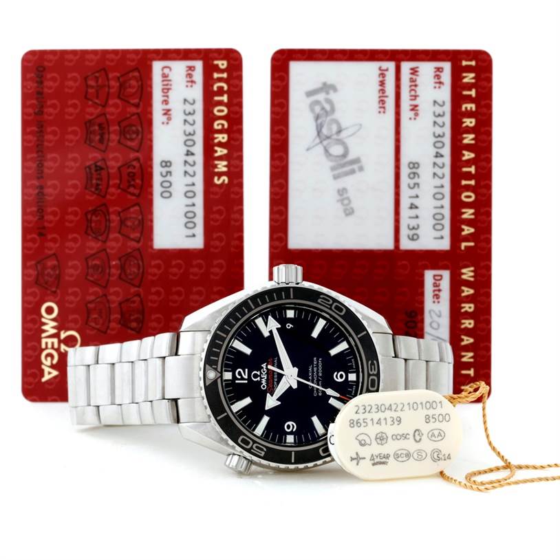 The Omega Planet Ocean 232.30.42.21.01.003 Men's Stainless Steel Black Dial 232.30.42.21.01.003 Men's Stainless Steel Black Dial watch is shown at a front angle with warranty cards and a tag beside it.