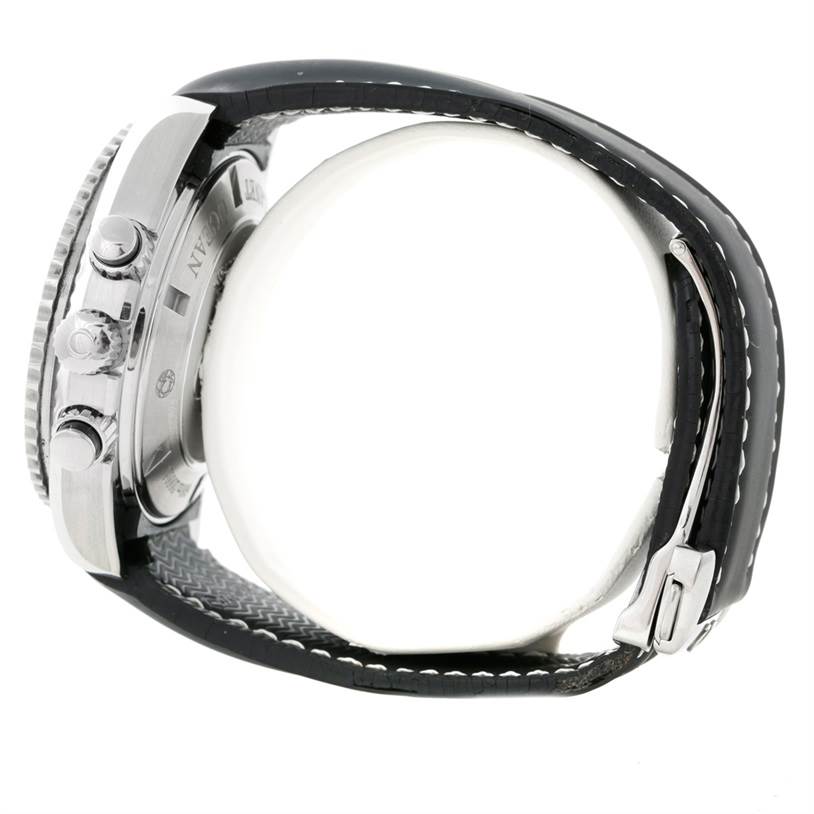 The image shows a side view of an Omega Planet Ocean 222.32.46.50.01.001 Men
s Stainless Steel Black Dial 222.32.46.50.01.001 Men
s Stainless Steel Black Dial watch, highlighting its case, buttons, and black strap with white stitching.