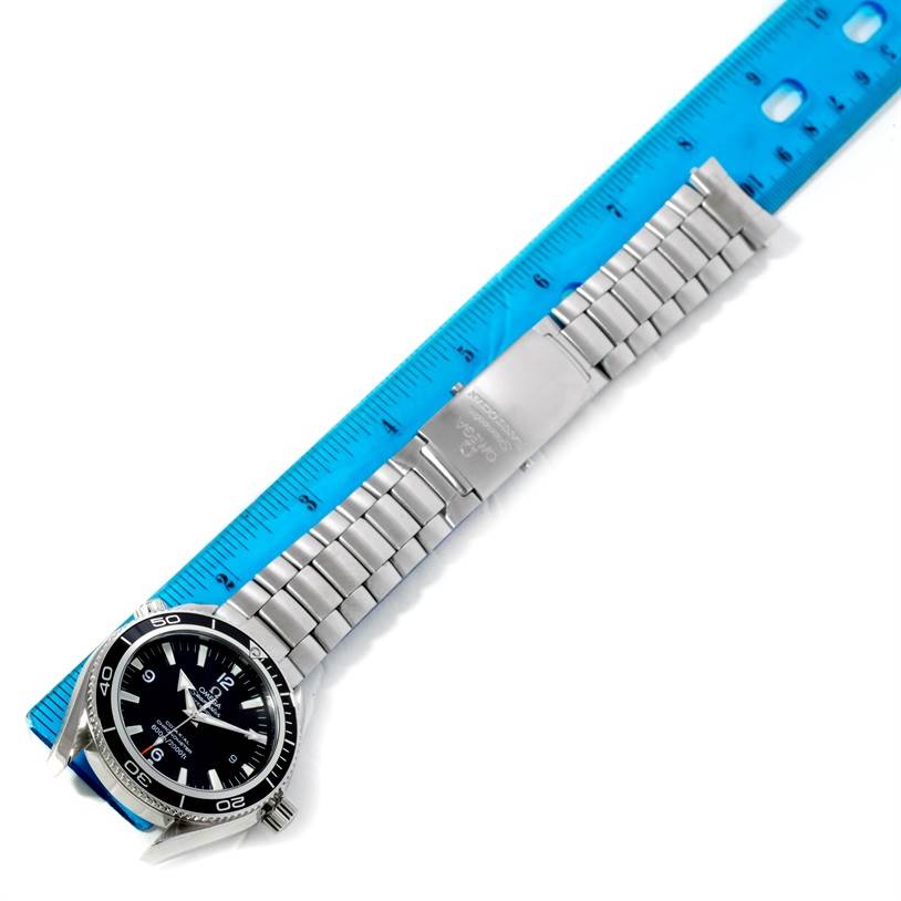 The image shows an Omega Planet Ocean 2201.50.00 Men
s Stainless Steel Black Dial 2201.50.00 Men
s Stainless Steel Black Dial watch at an angle, displaying the entire bracelet and part of the watch face, along a ruler.