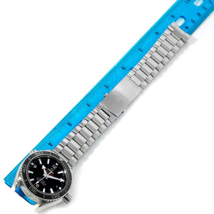 This image shows the Omega Planet Ocean 232.30.42.21.01.003 Men
s Stainless Steel Black Dial 232.30.42.21.01.003 Men
s Stainless Steel Black Dial watch laid flat, displaying the face, bezel, and metal bracelet alongside a ruler.