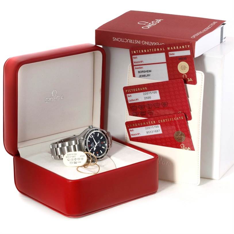 The Omega Planet Ocean 2201.51.00 Men's Stainless Steel Black Dial 2201.51.00 Men's Stainless Steel Black Dial watch is displayed in its open case with warranty cards and an operating instructions manual visible.