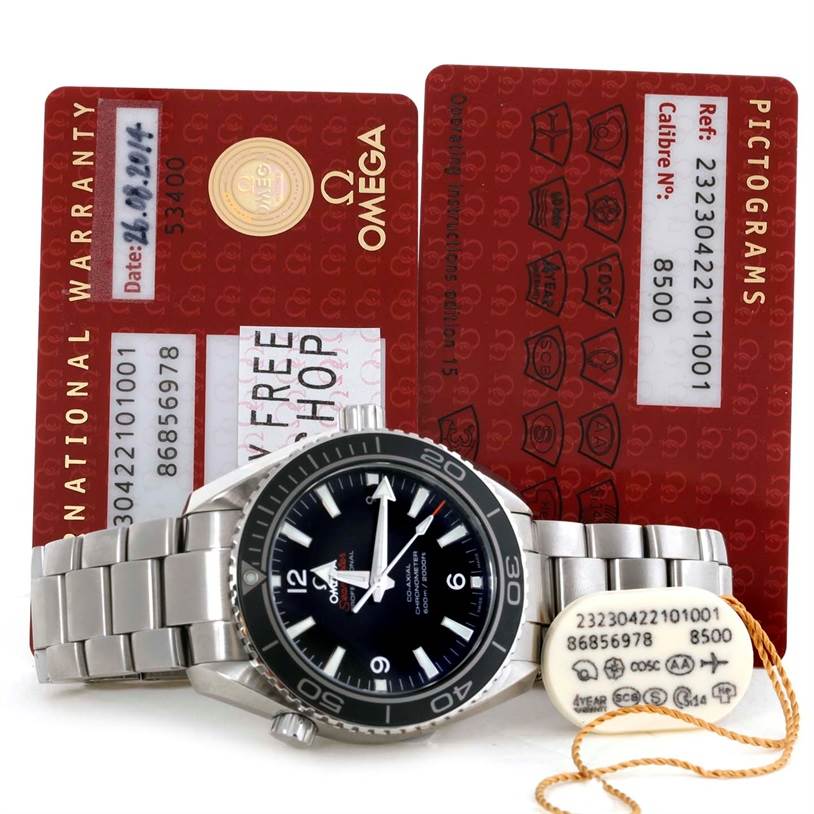 The image shows an Omega Planet Ocean 232.30.42.21.01.001 Men
s Stainless Steel Black Dial 232.30.42.21.01.001 Men
s Stainless Steel Black Dial watch and two red warranty cards positioned in the background.