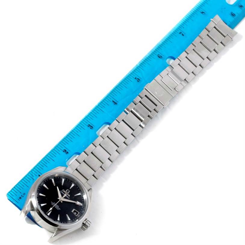 The image shows an Omega Aqua Terra 231.10.39.21.01.001 Men
s Stainless Steel Black Dial 231.10.39.21.01.001 Men
s Stainless Steel Black Dial watch lying flat beside a blue ruler, displaying the face and metal bracelet.