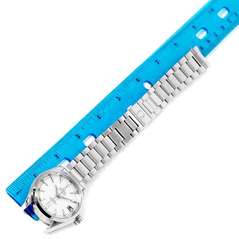 The image shows an Omega Aqua Terra 231.10.39.21.02.001 Men
s Stainless Steel Silver Dial 231.10.39.21.02.001 Men
s Stainless Steel Silver Dial watch positioned next to a blue ruler, displaying the face and metal bracelet from an angled top-down view.