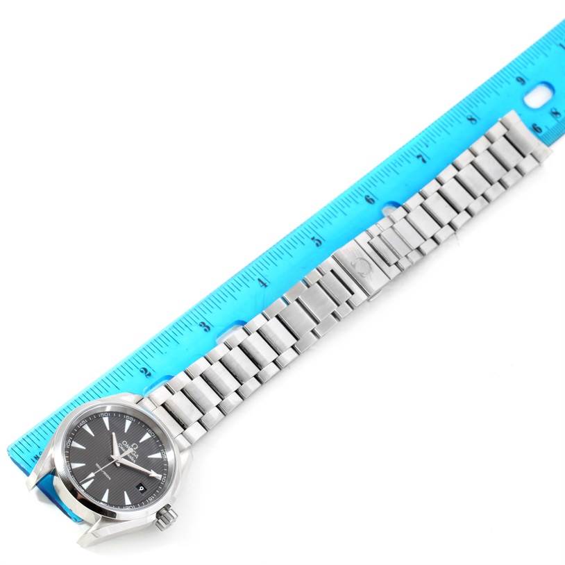 The Omega Aqua Terra 231.10.39.60.06.001 Men
s Stainless Steel Grey Dial 231.10.39.60.06.001 Men
s Stainless Steel Grey Dial watch is shown from a top-down angle, alongside a blue ruler for measurement.