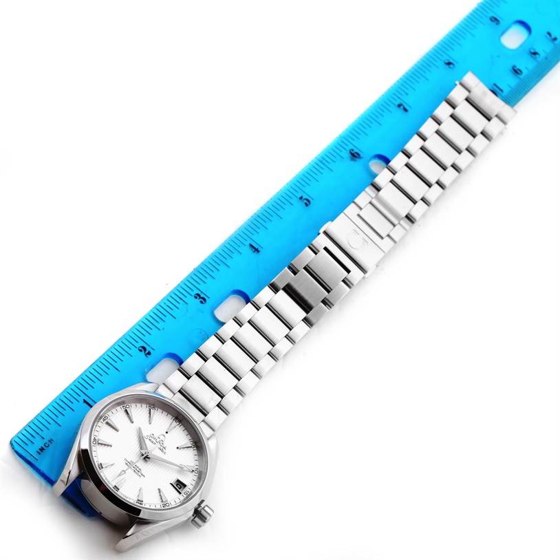 The Omega Aqua Terra 231.13.39.21.02.001 Men
s Stainless Steel Silver Dial 231.13.39.21.02.001 Men
s Stainless Steel Silver Dial watch is shown from a top-down angle, displaying its full length, including the face and metal bracelet, beside a ruler for scale.