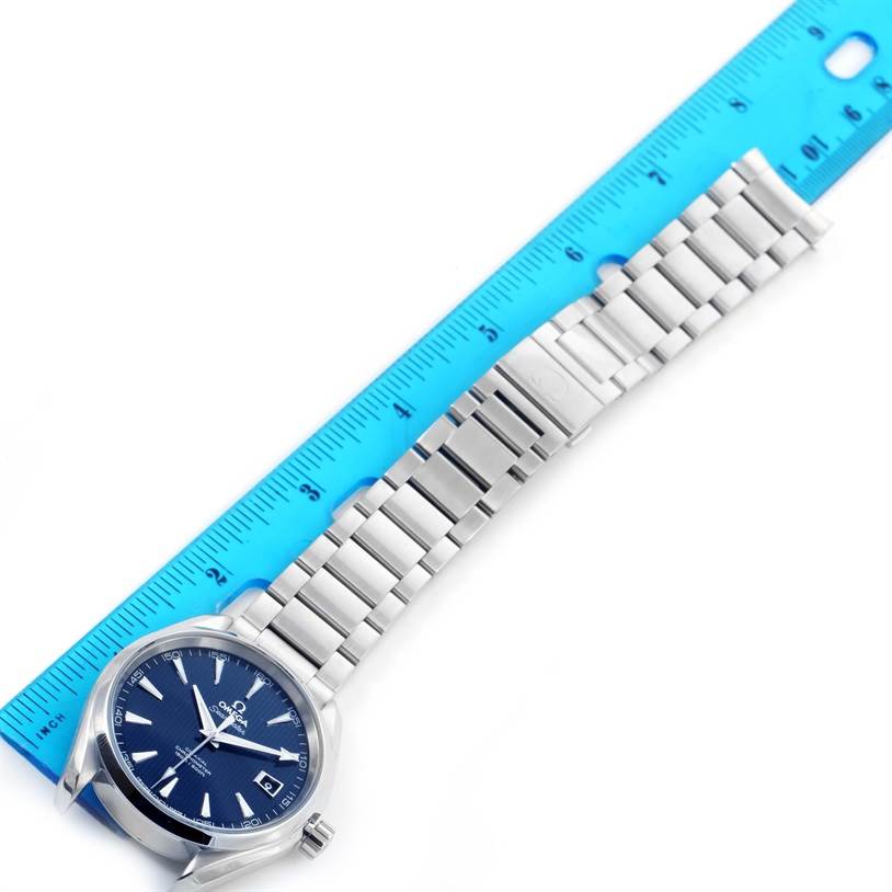 The image shows an Omega Aqua Terra 231.10.42.21.03.001 Men
s Stainless Steel Silver Dial 231.10.42.21.03.001 Men
s Stainless Steel Silver Dial watch with a blue dial and stainless steel band, placed next to a blue ruler for scale.