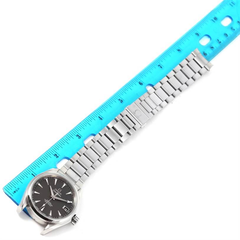 The image shows an Omega Aqua Terra 231.10.39.21.06.001 Men
s Stainless Steel Grey Dial 231.10.39.21.06.001 Men
s Stainless Steel Grey Dial watch laid flat next to a ruler, displaying its face, bracelet, and clasp.