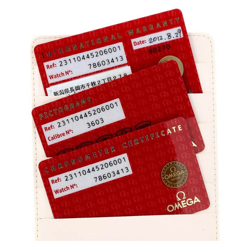 The image shows three red Omega cards for an Aqua Terra model watch, including the international warranty, pictograms, and chronometer certificate.