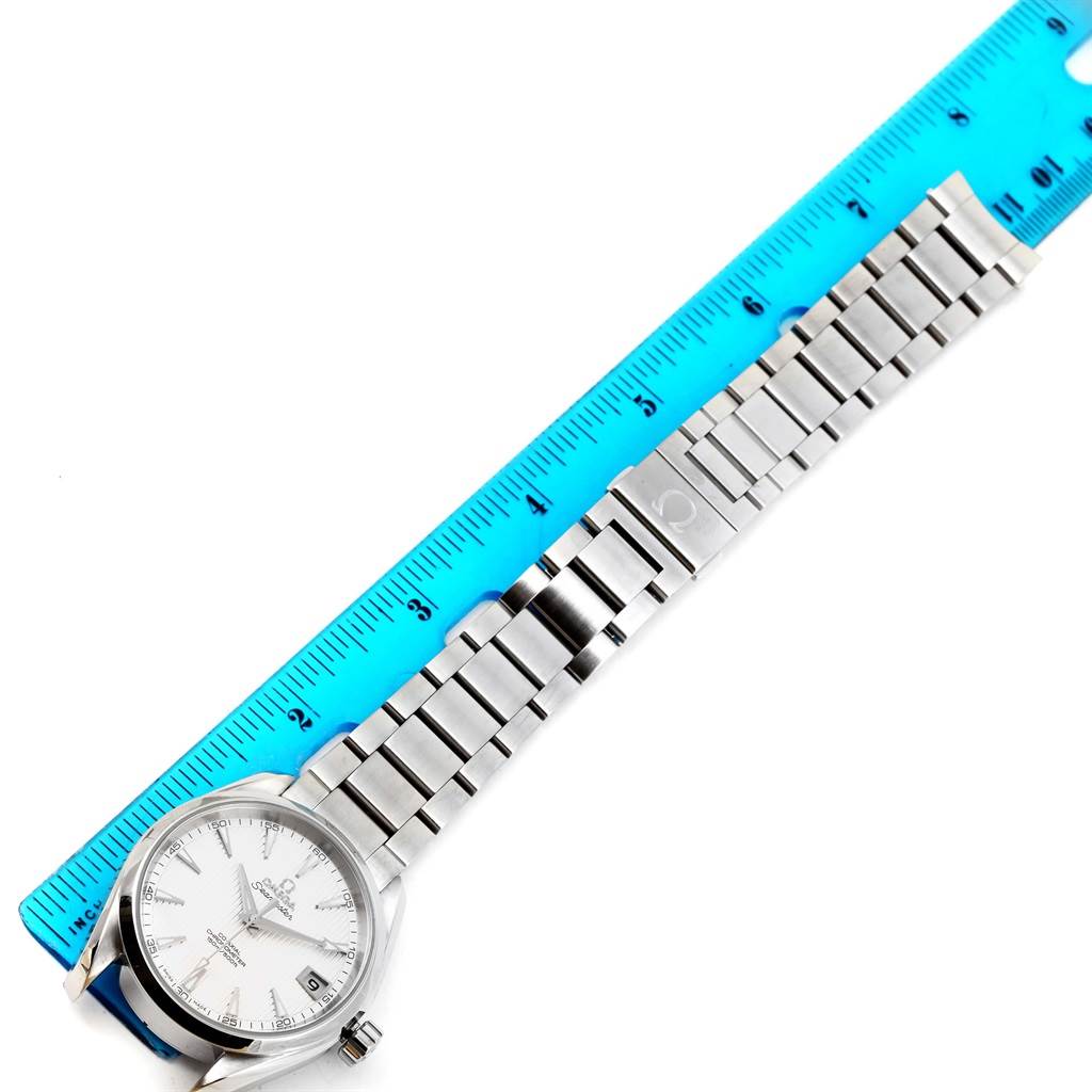 The image shows an Omega Aqua Terra 231.10.39.21.02.001 Men
s Stainless Steel Silver Dial 231.10.39.21.02.001 Men
s Stainless Steel Silver Dial watch laid flat alongside a blue ruler, highlighting both the watch face and metal bracelet.