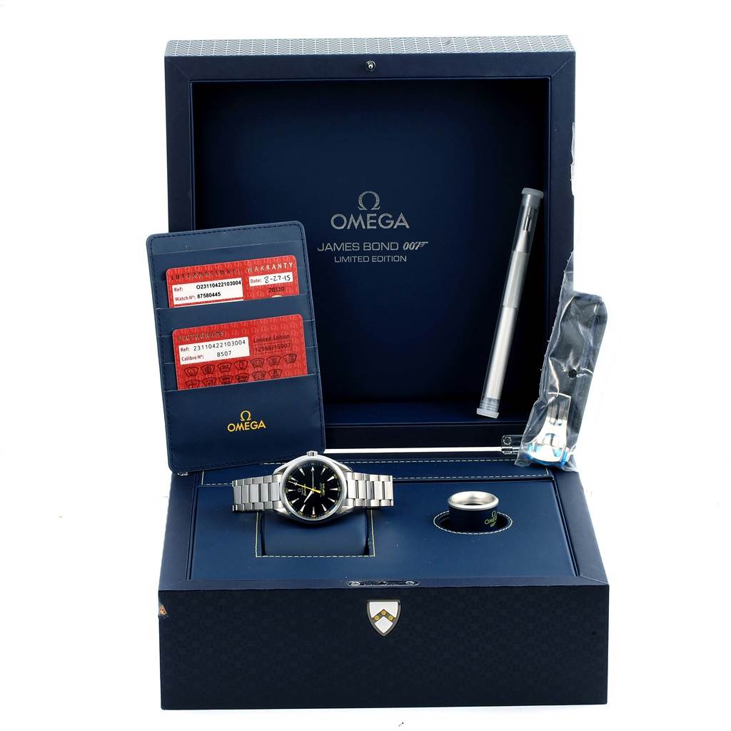 The image shows an Omega Aqua Terra 231.10.42.21.03.004 Men
s Stainless Steel Blue Dial 231.10.42.21.03.004 Men
s Stainless Steel Blue Dial James Bond Limited Edition watch, booklet, warranty cards, and additional accessories from a top angle.