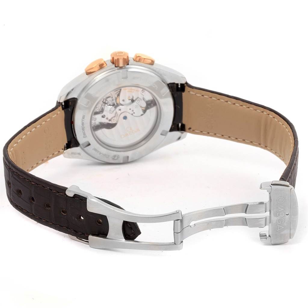 The image shows the back view of an Omega Aqua Terra 231.23.44.50.06.001 Men's Steel and Gold (two tone) Grey Dial 231.23.44.50.06.001 Men's Steel and Gold (two tone) Grey Dial watch, highlighting the transparent case back and brown leather strap with the clasp open.