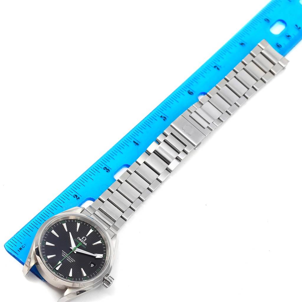 The image shows a top-down view of an Omega Aqua Terra 231.10.42.21.01.004 Men
s Stainless Steel Black Dial 231.10.42.21.01.004 Men
s Stainless Steel Black Dial watch, highlighting its face, bezel, and metal bracelet against a ruler for scale.