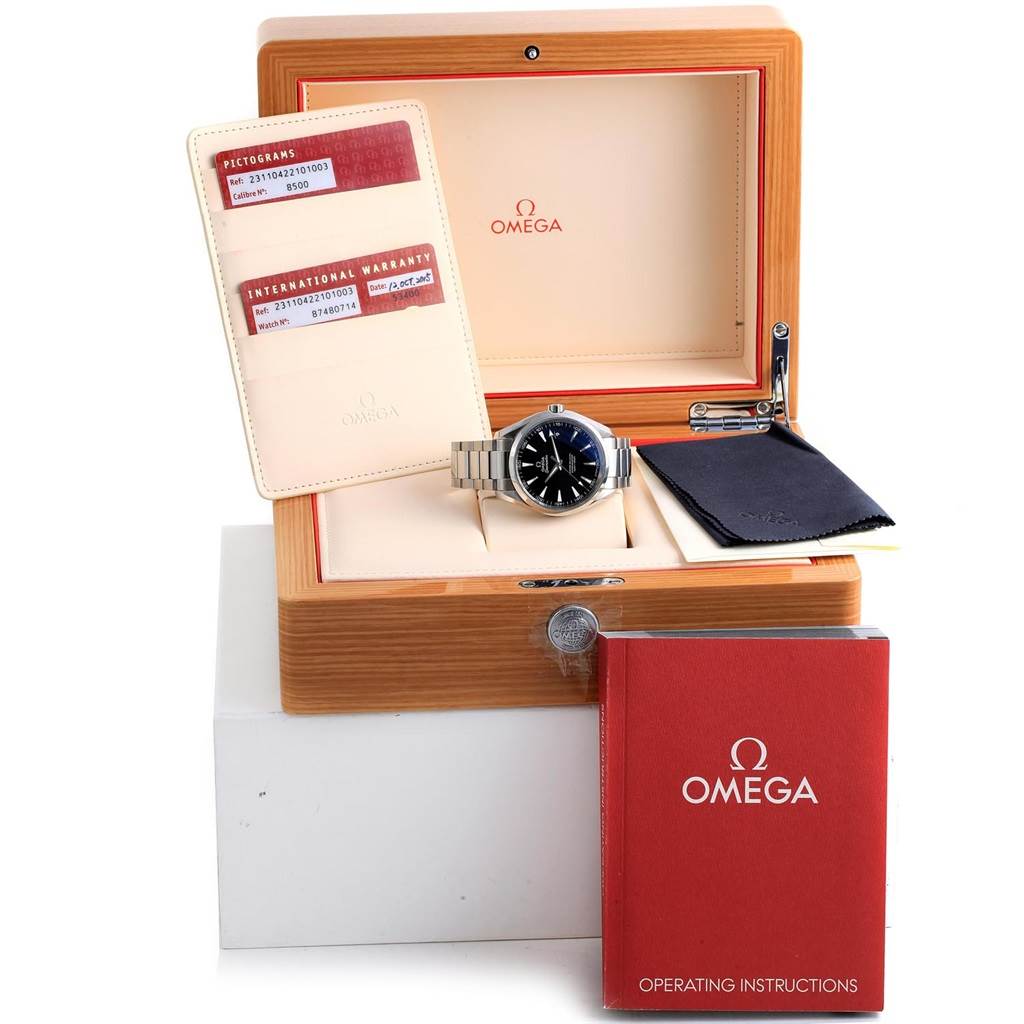 The Omega Aqua Terra 231.10.42.21.01.003 Men's Stainless Steel Black Dial 231.10.42.21.01.003 Men's Stainless Steel Black Dial watch is shown in its open box with warranty cards, a cleaning cloth, and an operating manual.
