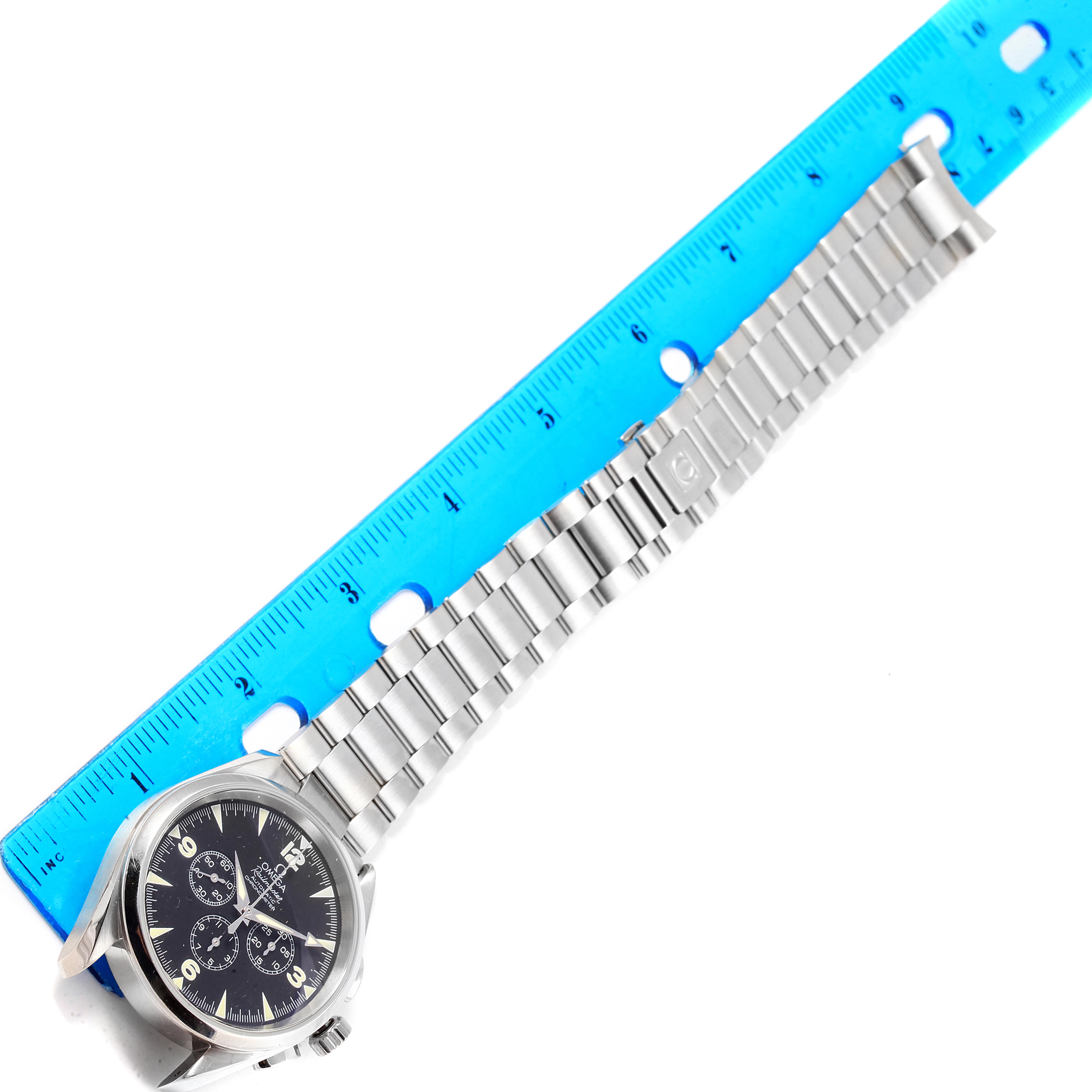 The image shows an Omega Aqua Terra 2512.52.00 Men's Stainless Steel Black Dial 2512.52.00 Men's Stainless Steel Black Dial watch placed next to a blue ruler, highlighting its steel bracelet and face.