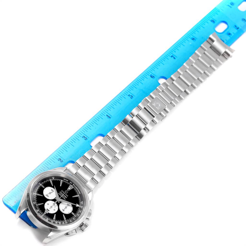 This image displays an Omega Aqua Terra 221.10.42.40.01.002 Men
s Stainless Steel Black Dial 221.10.42.40.01.002 Men
s Stainless Steel Black Dial watch laid flat alongside a measuring scale, showing the watch face and metal bracelet.