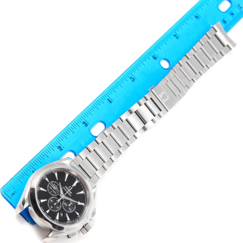 The image shows an Omega Aqua Terra 231.10.44.50.01.001 Men's Stainless Steel Black Dial 231.10.44.50.01.001 Men's Stainless Steel Black Dial model watch with a stainless steel bracelet, positioned diagonally next to a blue ruler.