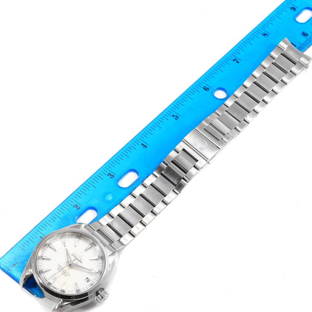 The image shows an Omega Aqua Terra 231.10.39.21.02.001 Men
s Stainless Steel Silver Dial 231.10.39.21.02.001 Men
s Stainless Steel Silver Dial watch laid flat next to a blue ruler, highlighting the watch face and metal bracelet.