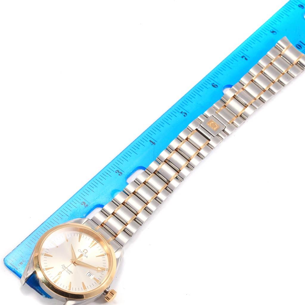 The Omega Aqua Terra 2317.30.00 Men's Steel and Gold (two tone) Silver Dial 2317.30.00 Men's Steel and Gold (two tone) Silver Dial watch is shown flat, with its dial, bracelet, and part of a blue ruler visible.