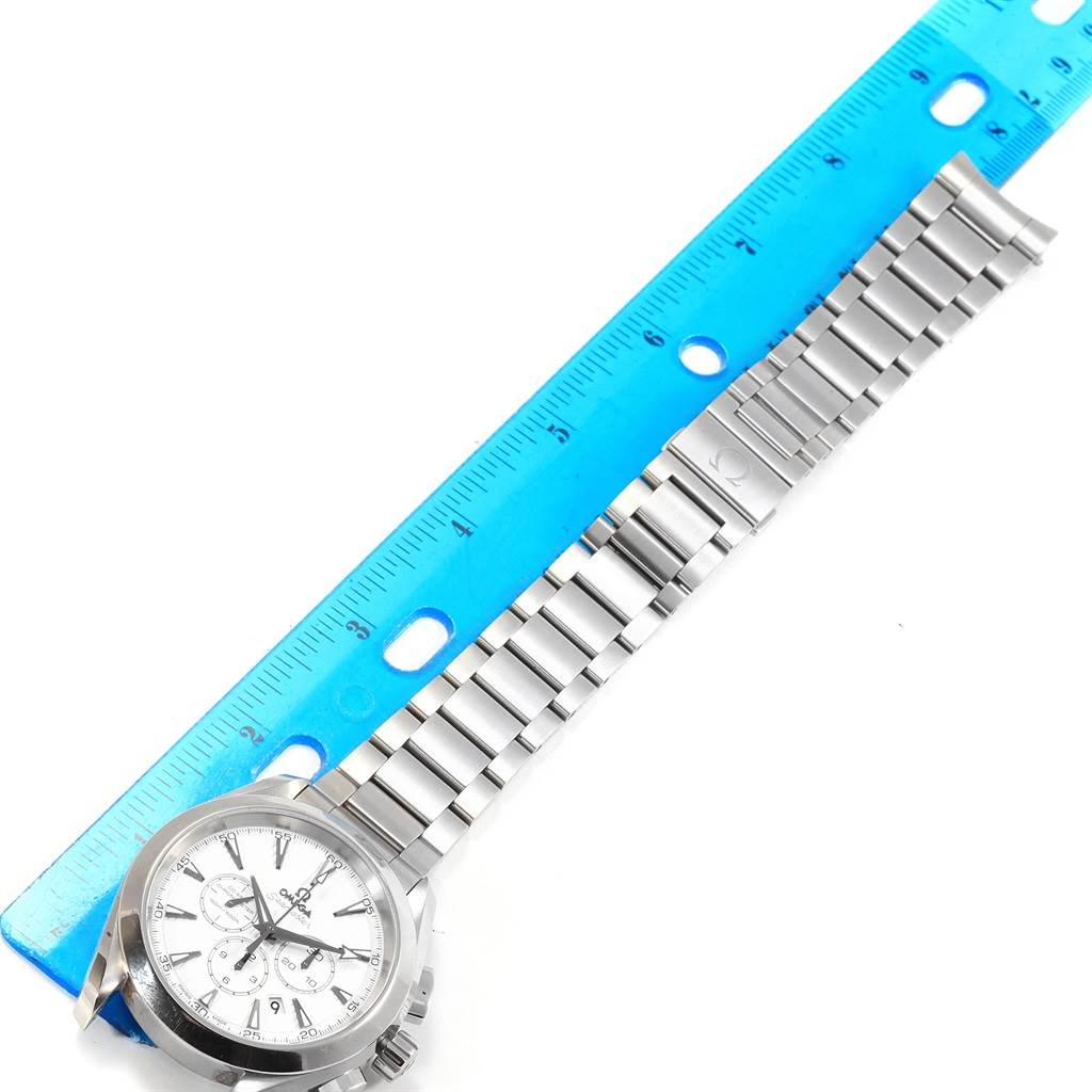 The image shows an Omega Aqua Terra 231.10.44.50.04.001 Men
s Stainless Steel White Dial 231.10.44.50.04.001 Men
s Stainless Steel White Dial watch laid flat next to a ruler, displaying its stainless steel strap and face.