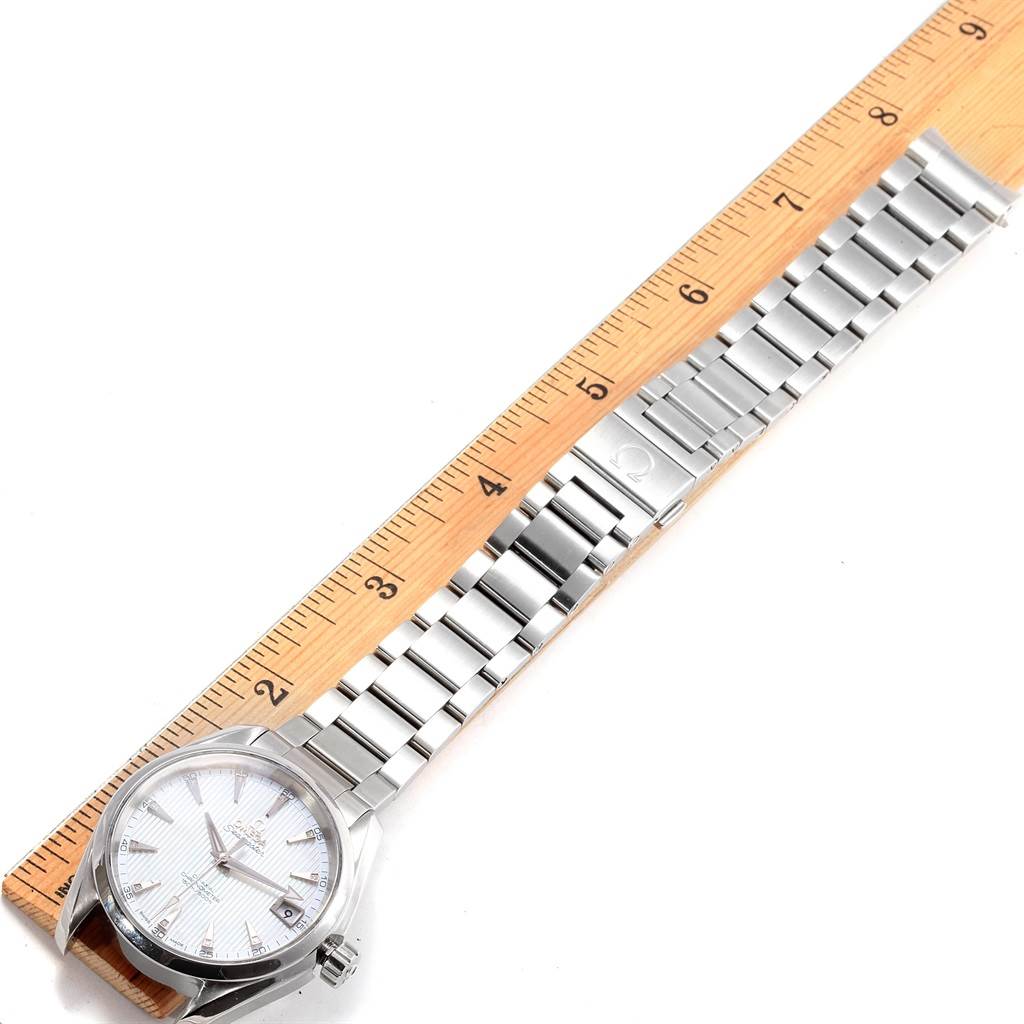 The Omega Aqua Terra 231.10.39.21.55.001 Men's Stainless Steel Mother of Pearl Dial 231.10.39.21.55.001 Men's Stainless Steel Mother of Pearl Dial watch is shown from a top-down angle alongside a ruler, highlighting the face and metal bracelet.