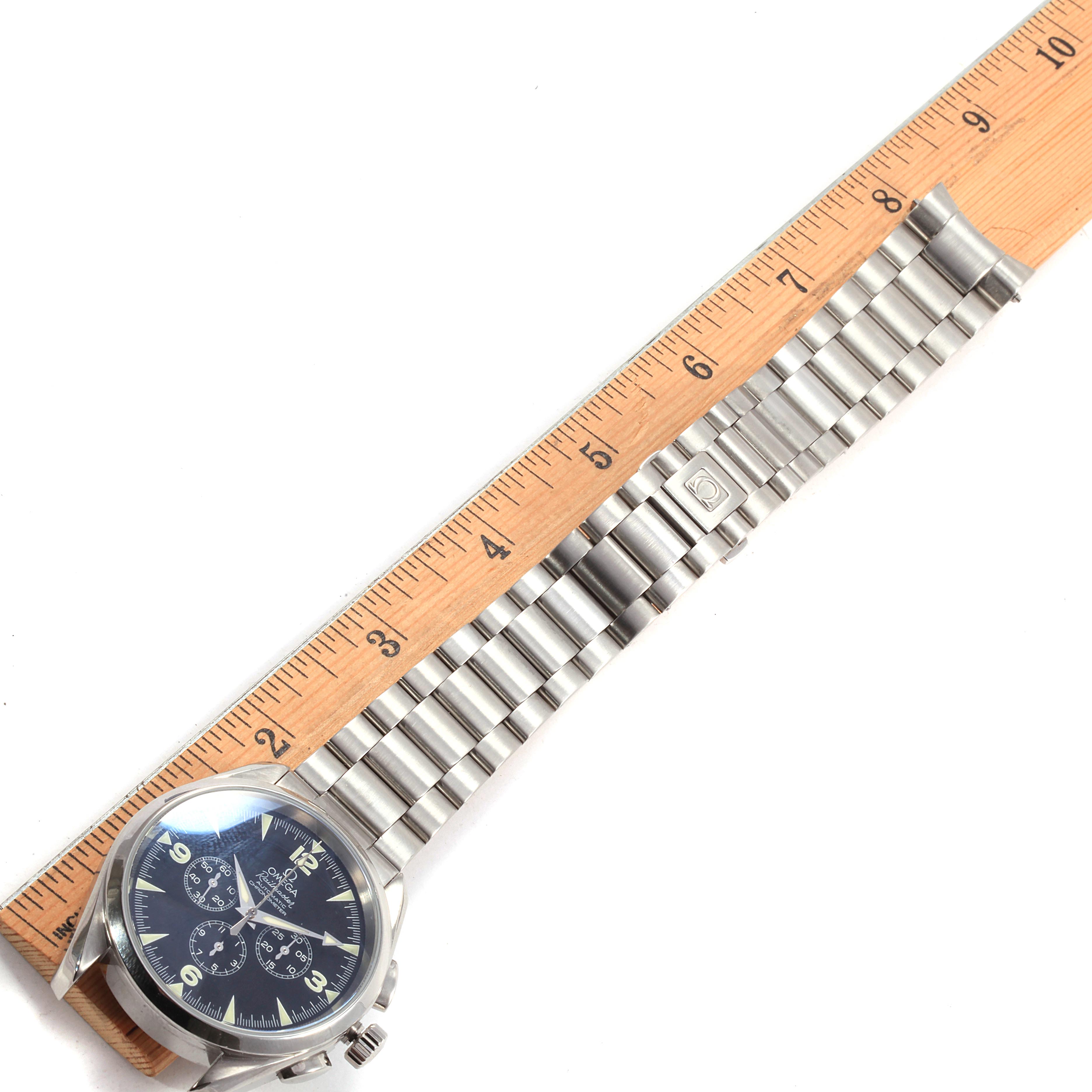 The image shows an Omega Aqua Terra 2512.52.00 Men's Stainless Steel Black Dial 2512.52.00 Men's Stainless Steel Black Dial watch placed alongside a ruler, highlighting its stainless steel bracelet and clasp.