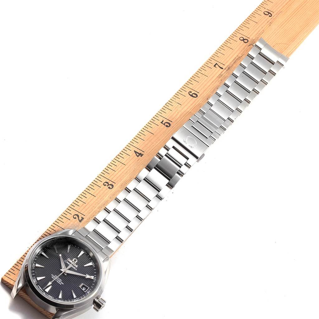 The Omega Aqua Terra 231.10.39.21.01.001 Men's Stainless Steel Black Dial 231.10.39.21.01.001 Men's Stainless Steel Black Dial watch is shown horizontally with its full bracelet and case, alongside a measuring ruler for reference.