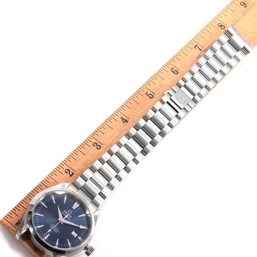 The image shows an Omega Aqua Terra 2503.80.00 Men's Stainless Steel Blue Dial 2503.80.00 Men's Stainless Steel Blue Dial watch laid flat with its stainless steel bracelet and a ruler for measurement.