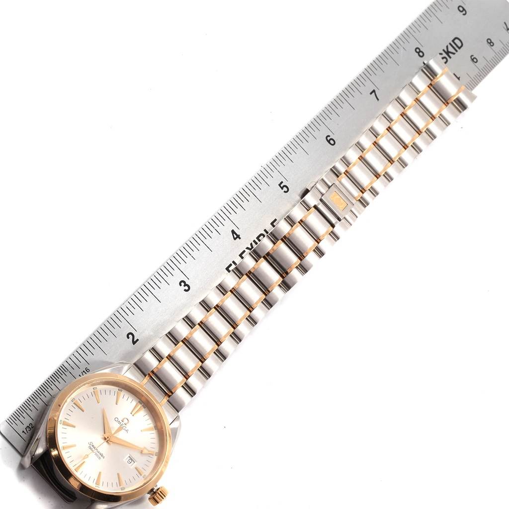 The Omega Aqua Terra 2317.30.00 Men's Steel and Gold (two tone) Silver Dial 2317.30.00 Men's Steel and Gold (two tone) Silver Dial watch is shown from a top-down angle, displaying the face, case, and metal bracelet beside a ruler.