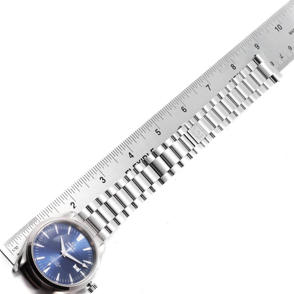 The image shows an Omega Aqua Terra 2502.80.00 Men's Stainless Steel Blue Dial 2502.80.00 Men's Stainless Steel Blue Dial watch laid flat with a stainless steel bracelet against a measuring ruler.