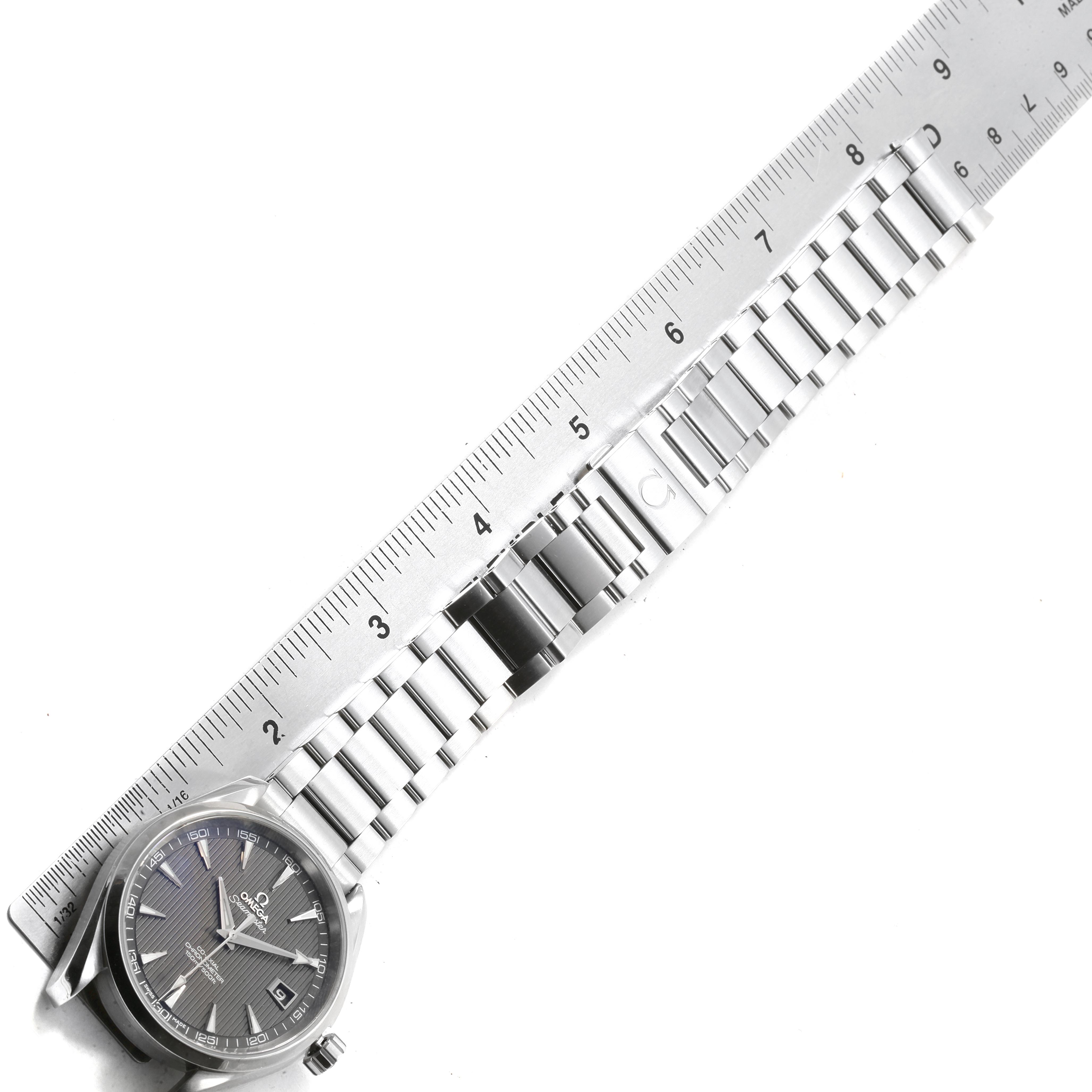 The image shows an Omega Aqua Terra 231.10.42.21.06.001 Men's Stainless Steel Grey Dial 231.10.42.21.06.001 Men's Stainless Steel Grey Dial watch laid next to a ruler, showcasing the watch face and stainless steel bracelet from a top-down angle.