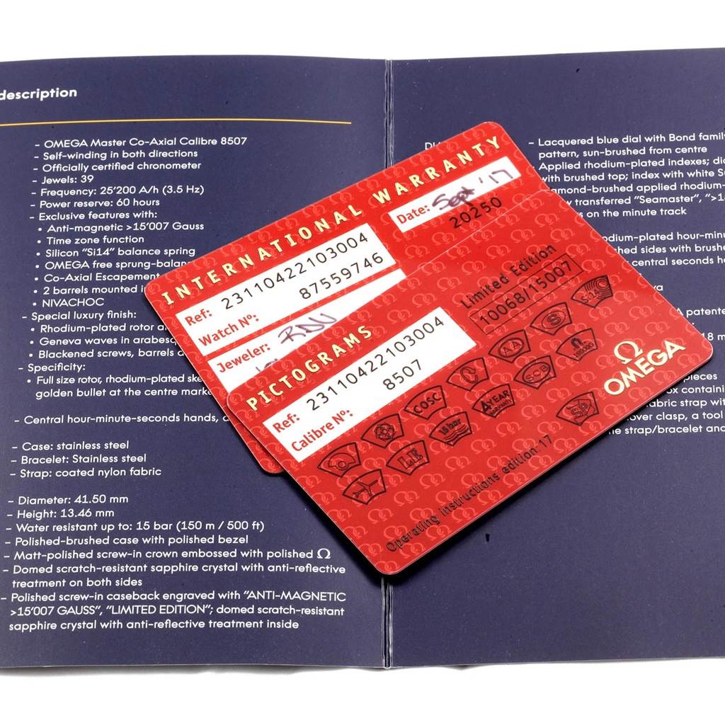 The image shows the warranty card and pictograms card for the Omega Aqua Terra 231.10.42.21.03.004 Men's Stainless Steel Blue Dial 231.10.42.21.03.004 Men's Stainless Steel Blue Dial model, angled over an opened booklet.