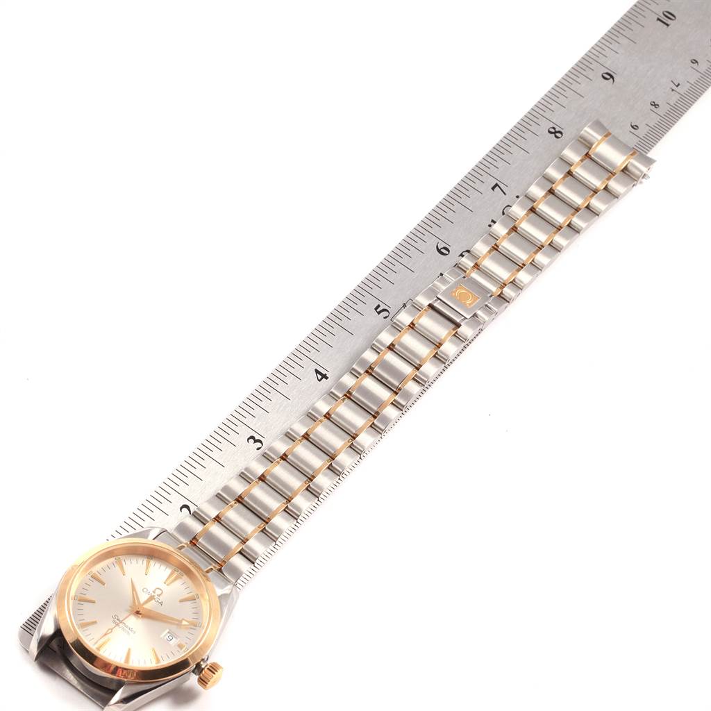 The image shows the Omega Aqua Terra 2317.30.00 Men
s Steel and Gold (two tone) Silver Dial 2317.30.00 Men
s Steel and Gold (two tone) Silver Dial watch laid flat next to a ruler, displaying the face and the length of the bracelet.