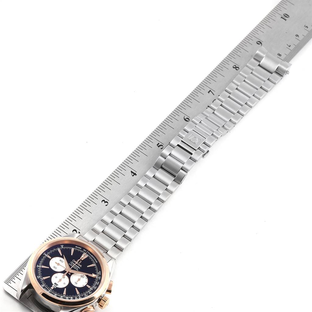 The Omega Aqua Terra 221.20.42.40.01.002 Men's Steel and Gold (two tone) Black Dial 221.20.42.40.01.002 Men's Steel and Gold (two tone) Black Dial watch is shown at an angle, with the dial and bracelet placed next to a ruler.