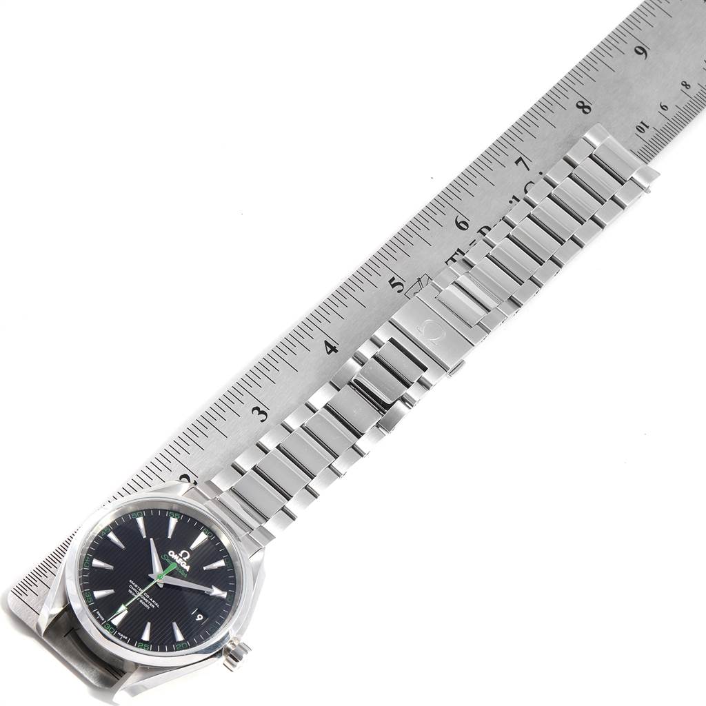 The image shows an Omega Aqua Terra 231.10.42.21.01.004 Men
s Stainless Steel Black Dial 231.10.42.21.01.004 Men
s Stainless Steel Black Dial watch laid next to a ruler, highlighting the watch face and metal strap.