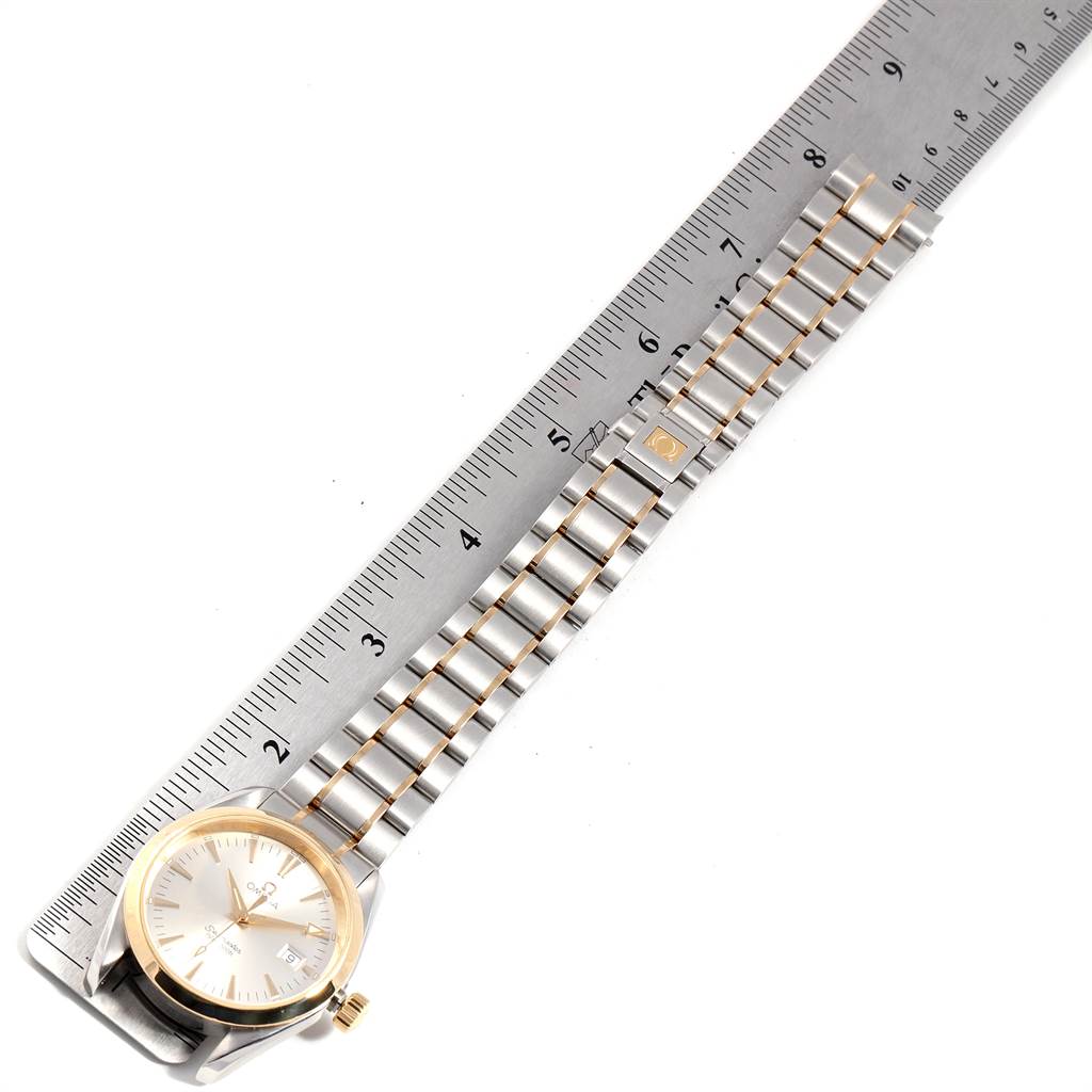 The image shows an Omega Aqua Terra 2317.30.00 Men
s Steel and Gold (two tone) Silver Dial 2317.30.00 Men
s Steel and Gold (two tone) Silver Dial watch and its bracelet laid out next to a ruler for measurement.
