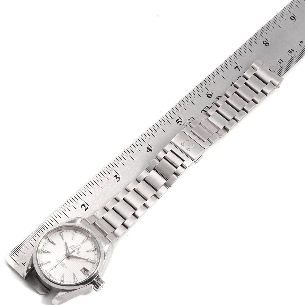The Omega Aqua Terra 231.10.39.21.02.001 Men
s Stainless Steel Silver Dial 231.10.39.21.02.001 Men
s Stainless Steel Silver Dial watch is shown from a top-down angle, including its face, bracelet, and partial view of a clasp next to a ruler.