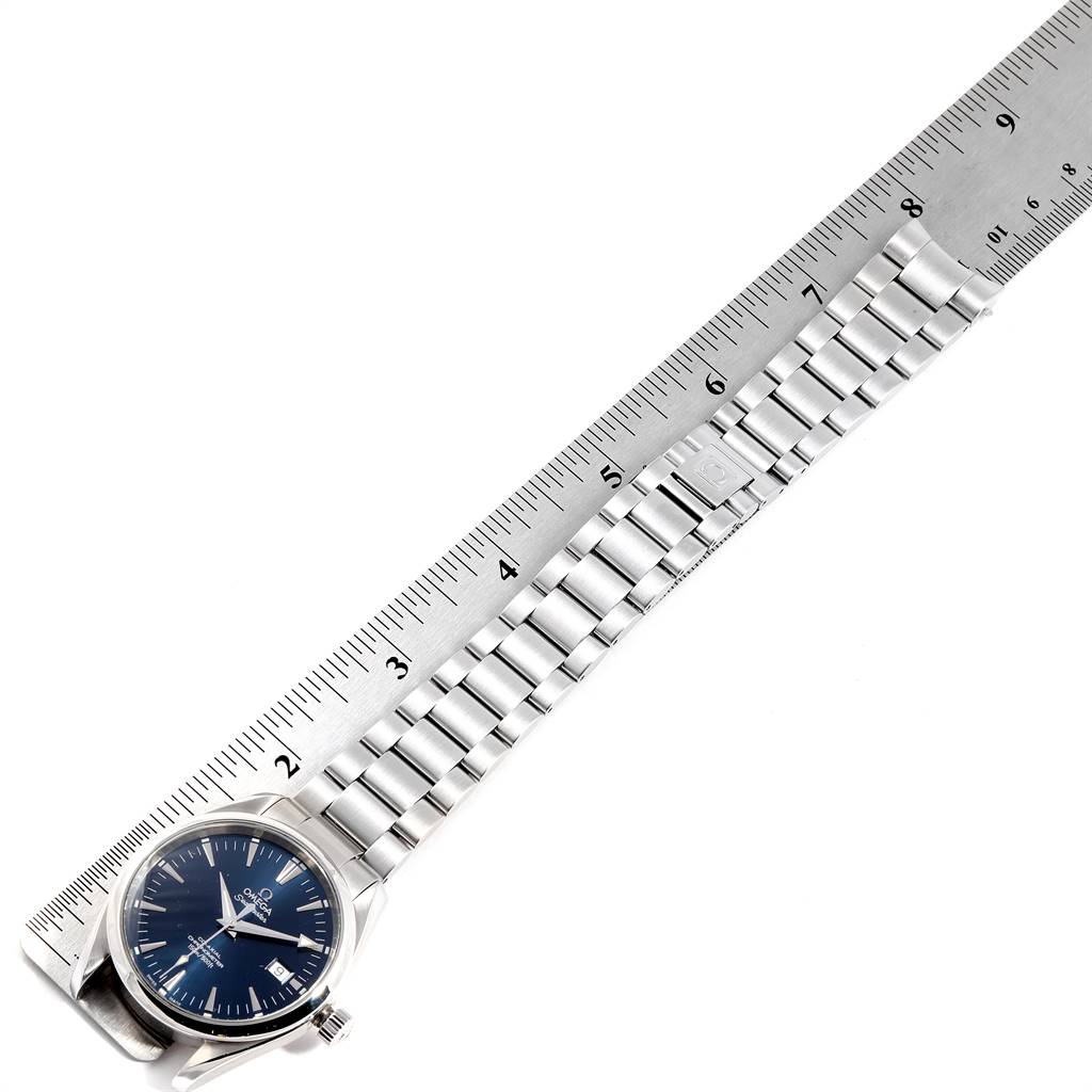 The image shows an Omega Aqua Terra 2503.80.00 Men
s Stainless Steel Blue Dial 2503.80.00 Men
s Stainless Steel Blue Dial watch laid flat next to a ruler, highlighting the stainless steel bracelet and blue dial.