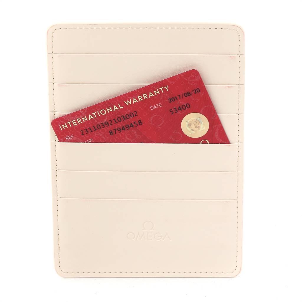 The image shows an Omega warranty card for the Aqua Terra model placed in a beige cardholder.