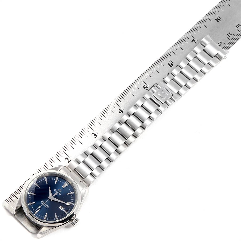 The image shows an Omega Aqua Terra 2517.80.00 Men
s Stainless Steel Blue Dial 2517.80.00 Men
s Stainless Steel Blue Dial watch laid flat with its stainless steel bracelet next to a ruler, viewed from above.