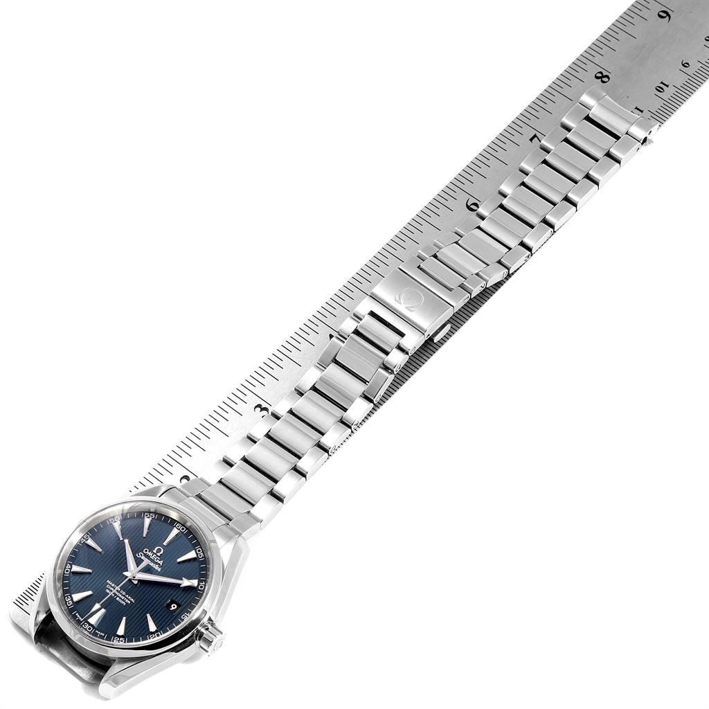 The image shows an Omega Aqua Terra 231.10.42.21.03.003 Men's Stainless Steel Blue Dial 231.10.42.21.03.003 Men's Stainless Steel Blue Dial model watch laid flat against a ruler, displaying the watch face and full metal bracelet.