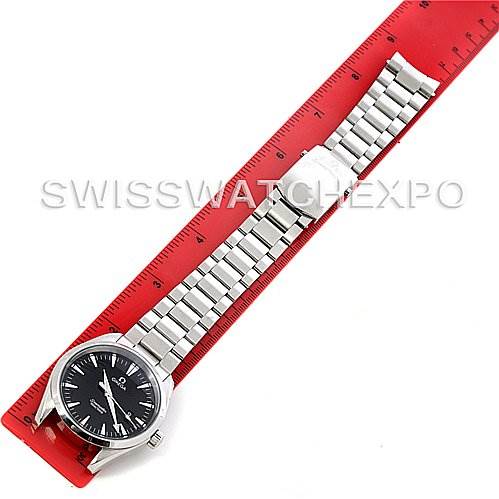 The image shows an Omega Aqua Terra 2517.50.00 Men
s Stainless Steel Black Dial 2517.50.00 Men
s Stainless Steel Black Dial watch laid flat next to a red ruler, showcasing its stainless steel bracelet and black dial.