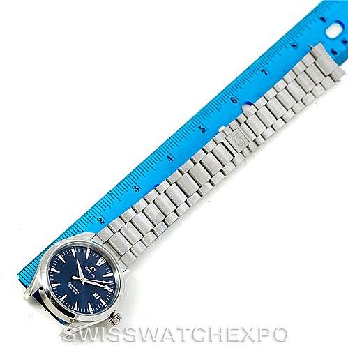The image shows an Omega Aqua Terra 2517.80.00 Men
s Stainless Steel Blue Dial 2517.80.00 Men
s Stainless Steel Blue Dial watch featuring its face and metal bracelet, measured next to a blue ruler.