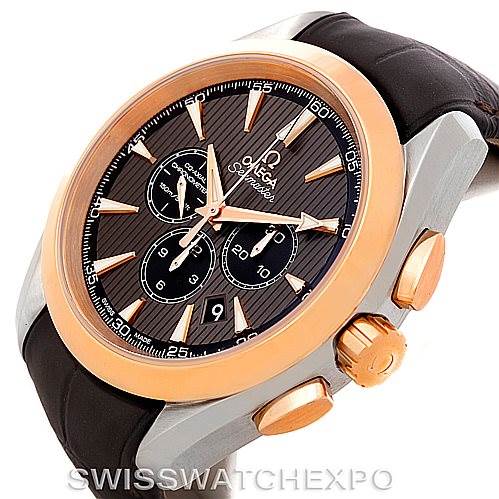 This is an angled view of the Omega Aqua Terra 231.23.44.50.06.001 Men's Steel and Gold (two tone) Grey Dial 231.23.44.50.06.001 Men's Steel and Gold (two tone) Grey Dial watch showing the face, crown, and pushers, with a leather strap.